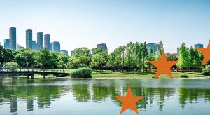 Panorama urbano con parco verde e lago, simbolo della sostenibilità urbana presentata durante l'infoday dedicato ai bandi e programmi europei